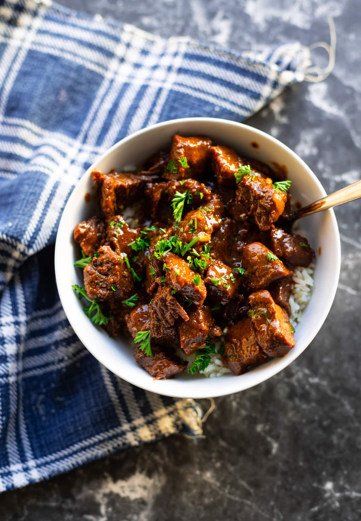 Bowl filled with steak bites covered in sauce.
