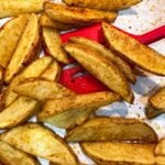 Close up of a person serving steak fries.