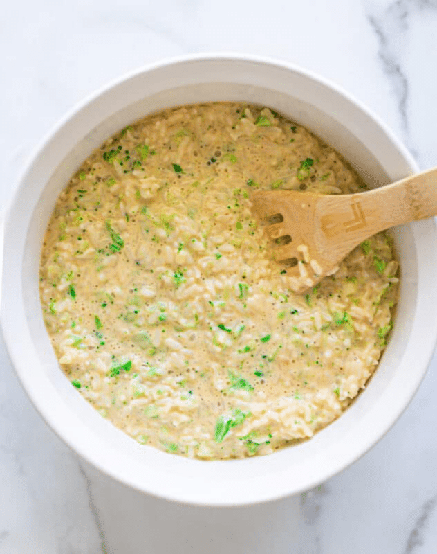Uncooked broccoli and rice in a casserole dish.