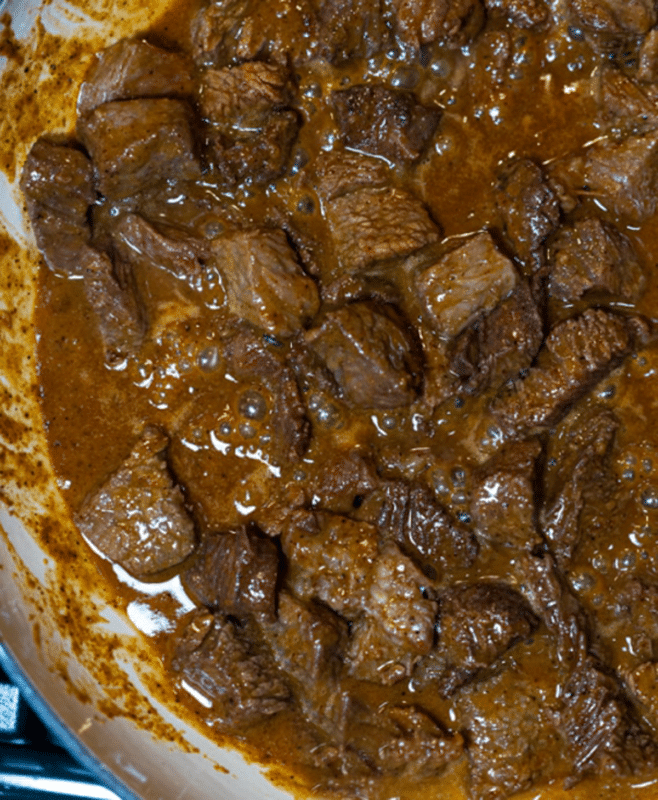 Steak bites cooking in a pan.