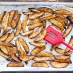 Spatula flipping steak fries from the oven.